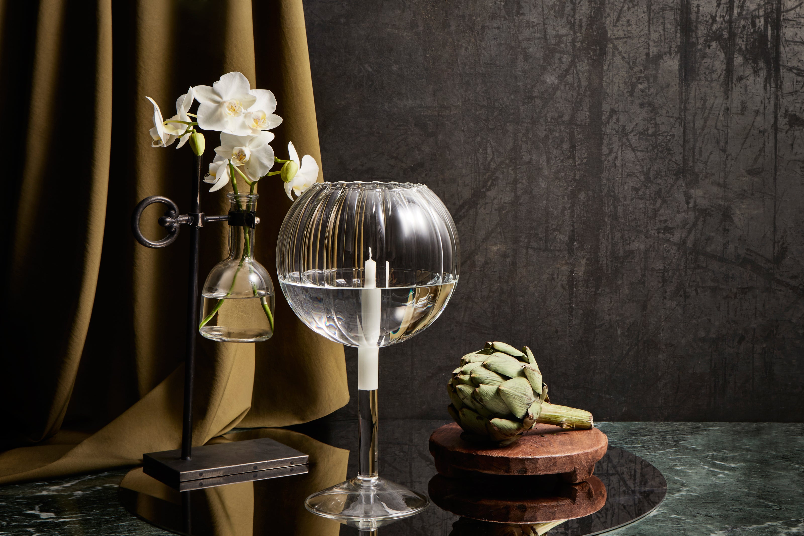 Decorative glass candleholder containing an unlit floating candle on a circular mirror: ≲ 231 MIN ribbed candleholder.