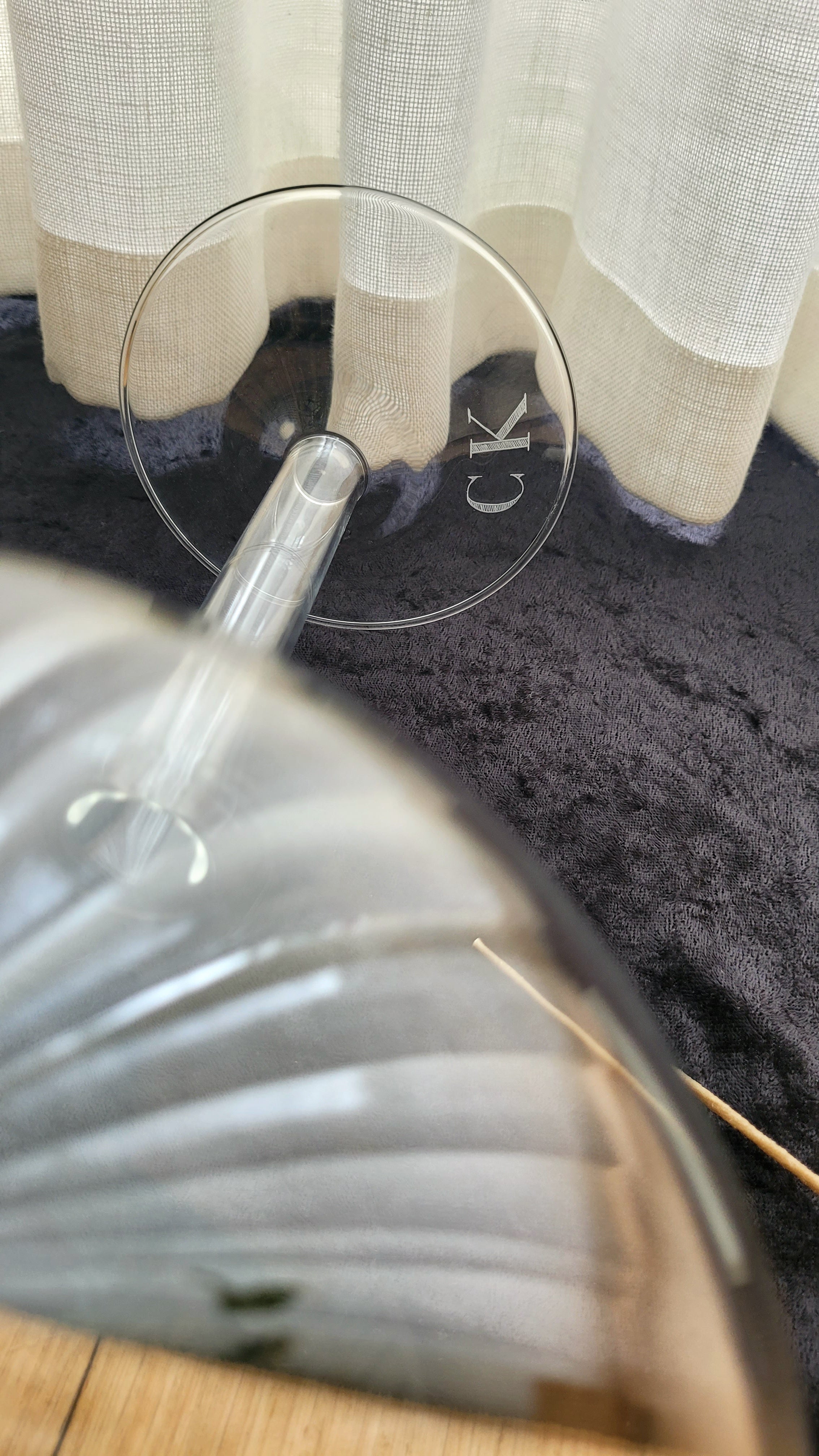 Close-up of a glass candleholder with initials engraved onto the base